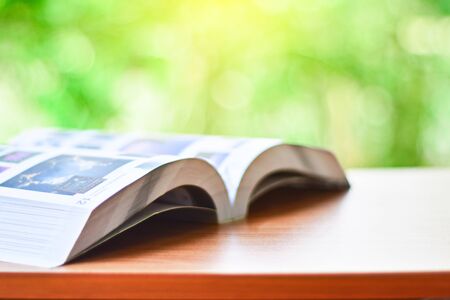 Open book on table on natural background with sunlight and copy space