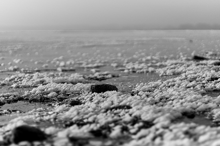 Thin, transparent ice and snow on a frozen lake in Bavariaの写真素材