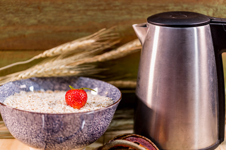 Strawburry in malt serial with hot pot on wood background