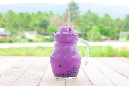 taro milk tea smoothie on a wooden tableの写真素材