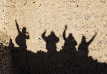 Shadow of four happy tourists on the brick wall in Leh,Ladakh,Kashmir,India