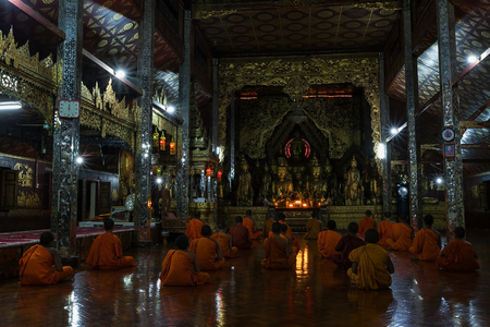 Keng Tung(Kyainge Tong),Myanmar-Oct 23,2011;Assembly of monks during the evening ritual pray in front of buddha statues in beautiful Myanmar architecture hall at ancient templeのeditorial素材