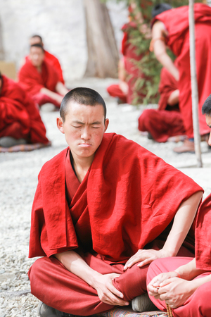Lhasa,Tibet-8 Apr 2013;Dharma debating,Tibetan buddhist lama are debating with aggressive manner in courtyard at Sera monastery every afternoon.This debating is a traditional learning style.のeditorial素材