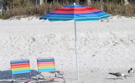 secluded beach chairs and umbrella on the sandy beaches of Floridaの写真素材