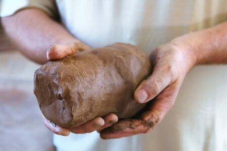 Male hand hold piece of clay.の写真素材