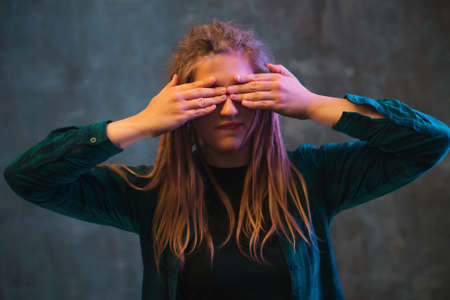 Young woman with dreadlocks in colorful neon lighting. Stylish girl on dark background.