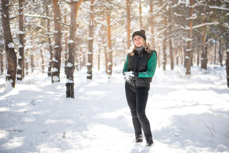 Woman plays snowballs in winter forest. Camping concept.の写真素材