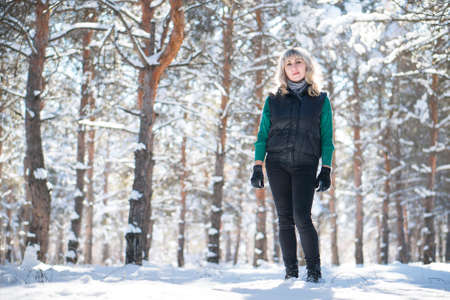 Woman in wintertime outdoor. Walking in snowy forest.の写真素材