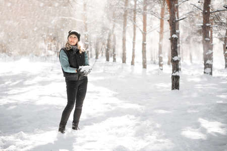 Woman in forest during blizzard. Unexpected snowstorm and snowfall concept.の写真素材