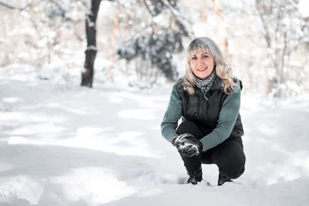 Woman plays snowballs in park. Camping and winter concept.の写真素材