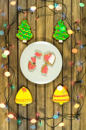 Gingerbread cookies on wooden table surrounded by lighting chain. Holiday concept. Christmas mood.の写真素材