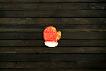 Gingerbread in shape of Christmas gantlet. Cookie on wooden background. Holiday concept with copy space.の写真素材