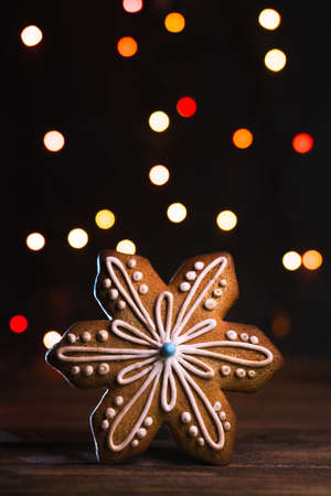 Gingerbread in shape of Christmas snowflake. Cookie on blurred background, soft focus, copy space.の写真素材
