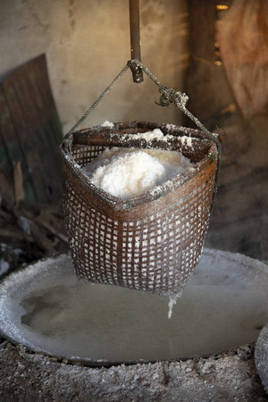 Salt in a basket hung above the boiler on the burner.の写真素材