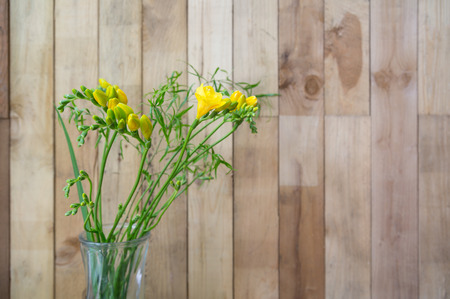 still life of yellow freesia flowers on wooden backgroundの写真素材