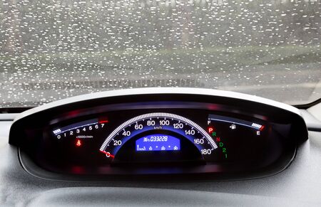 dashboard and rain droplets on car windshield