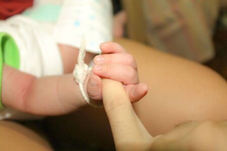 Infant holding father's finger. 2 months old baby holding his dad 's left little finger. First love. Really true love. Happy family.の写真素材
