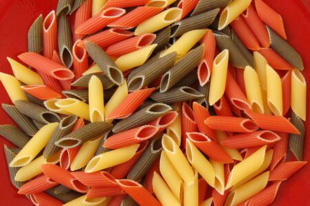 Three colored pens pasta. Italian food on red background.の写真素材