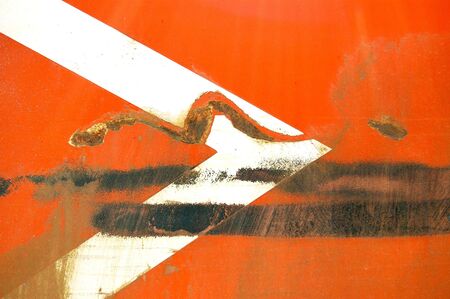 Arrow stencil on industrial metal surface. Scratched paint and rust macro background.の写真素材