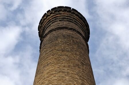 Weathered brick chimney of an abandoned factory.の写真素材
