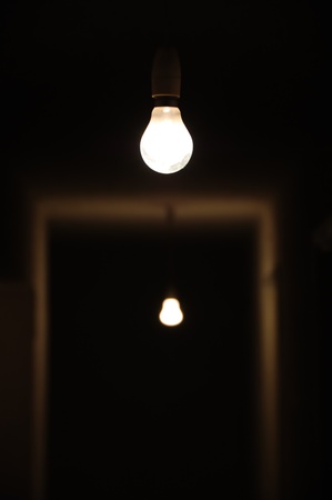 Bare light bulbs in dark underground hallway.の写真素材