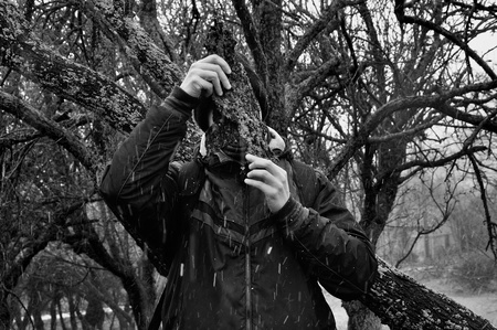 Man with bark peel snow storm in forest. Black and white.