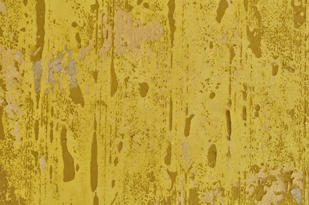 Peeling paint yellow wall and pieces of torn wallpaper. Background texture.の写真素材