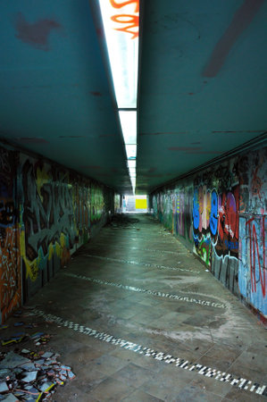 Dirty pedestrian underpass under the motorway. Smashed tiles and smudged walls.のeditorial素材