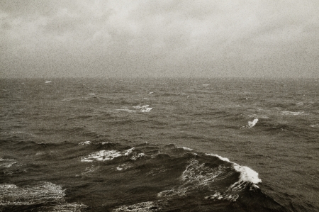 Winter sea waves and cloudy sky horizon. Black and white with grain texture.の写真素材