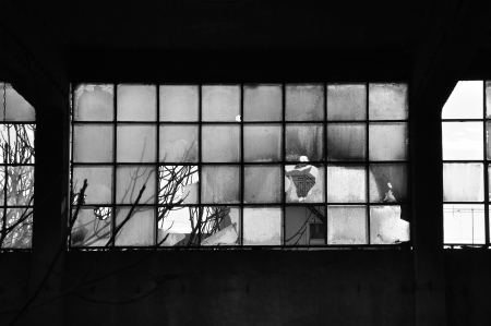 Broken windows and concrete wall in abandoned factory  Black and white 