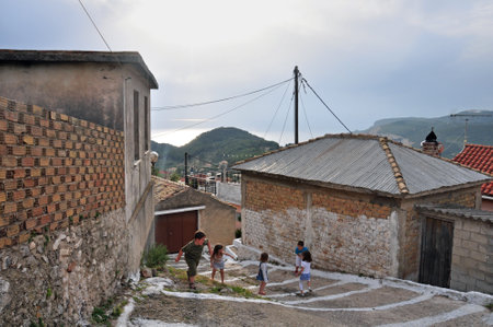 ZAKYNTHOS - MAY 6: Children playing on narrow alley, mountain village Keri, island of Zakynthos, Greece, May 6, 2013.のeditorial素材