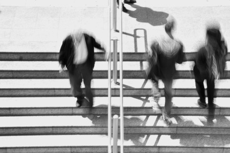 People on subway station stairway abstract motion blur. Black and white.