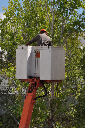 ATHENS GREECE  OCTOBER 2 2013: Worker on crane basket man box talking on mobile phone. Working at height dangerous occupation.のeditorial素材