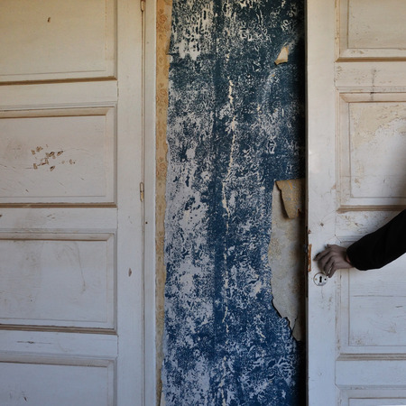 Creepy doll hand on the door of a haunted abandoned house.の写真素材