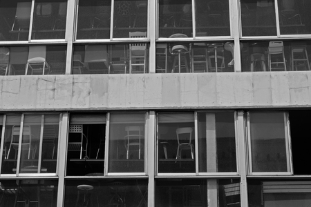 Chairs for sale behind dusty windows. Black and white.