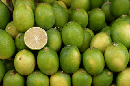 Lime lemons at grocery store. Fresh citrus fruit background.の写真素材
