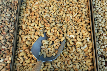 Cashews and other dried nuts for sale. Roasted salty snacks food background.の写真素材
