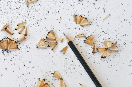 Sharpened pencil and shavings on white paper background.の写真素材