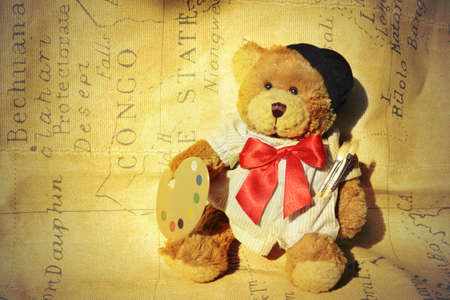 background teddy dressed as a painter with a background mapの写真素材