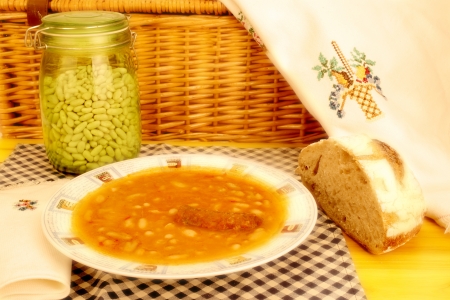 plate of beans with chorizo, Spanish traditional and homemade bread on wooden tableの写真素材