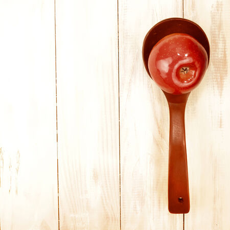red apple on a wooden spoon with copy spaceの写真素材