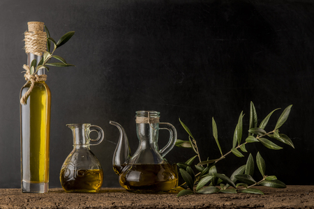 Bottle and glass jars of extra virgin olive oil on rustic backgroundの写真素材