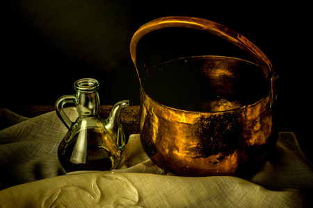 Olive oil and old copper pot on the tableの写真素材