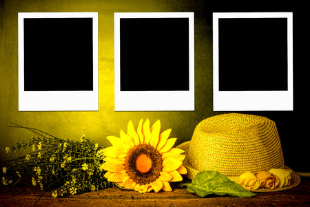 Three instant photo frames, summer hat and sunflower backgroundの写真素材