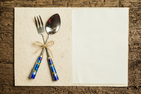 Menu background, vintage set cutlery and empty paper parchment on rustic wood background with blank space for textの写真素材