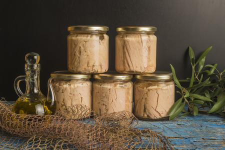 Tuna canned in jars with olive oil on blue rustic table, albacore Cantabrian seaの写真素材