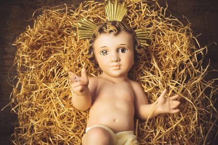 Christmas greeting card, Baby Jesus vintage figurine on old wooden table.の写真素材