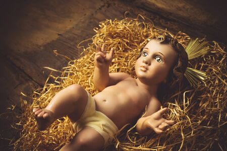 Christmas greeting card, Baby Jesus vintage figurine on old wooden table.の写真素材
