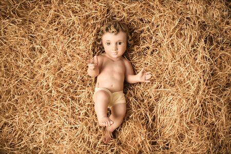 Christmas greeting card, Baby Jesus vintage figurine in his crib.の写真素材