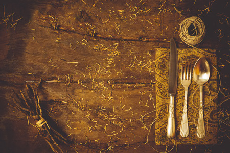 Humble menu Christmas concept, old cutlery on old  empty wooden table decorated with straw and woodの写真素材
